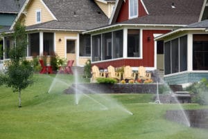 red house with sprinkler system in the yard